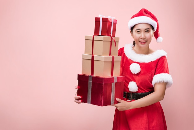 Uma linda mulher fantasiada de Papai Noel com muitas caixas de presente por ocasião do Feliz Natal e Feliz Ano Novo.