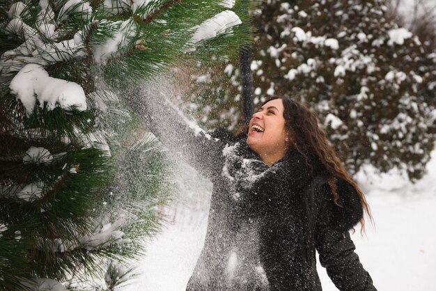 Uma linda mulher grávida está brincando lá fora na neve