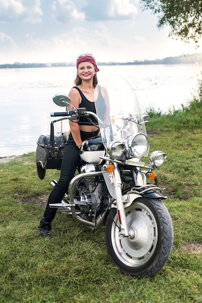 Uma linda mulher loira sentada em uma motocicleta