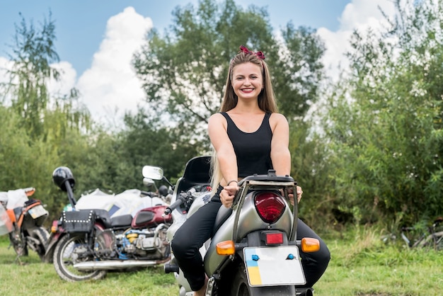 Uma linda mulher loira sentada em uma motocicleta