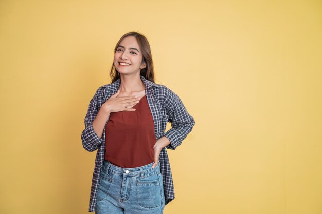 Uma linda mulher sorrindo com um gesto de mão no peito e uma expressão calma com copyspace