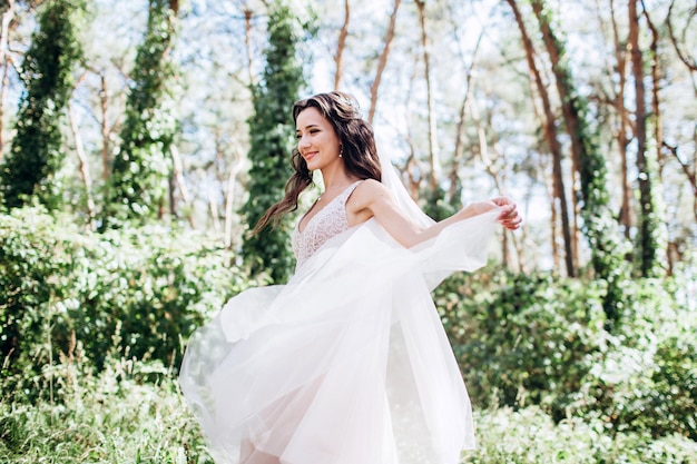 Uma linda noiva em um vestido rosa delicado ao ar livre, retrato de uma mulher morena com longos cabelos escuros