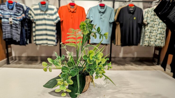 uma loja com uma grande exposição de camisa de homem e vestido de mulher nas prateleiras