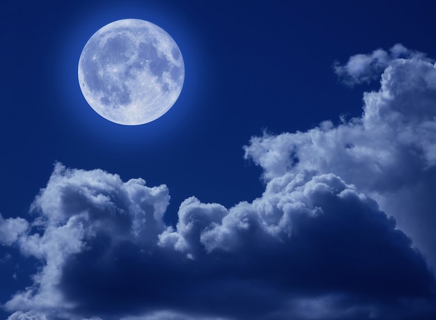 Uma lua cheia em um céu noturno trágico com nuvens. Uma cena de Halloween com uma cópia do espaço.