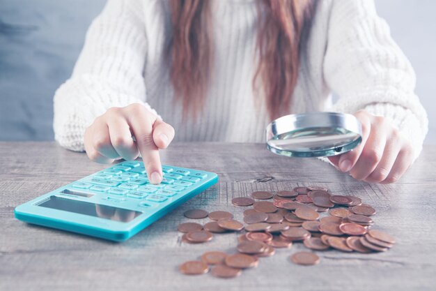 Uma lupa examina o dinheiro e calcula em uma calculadora
