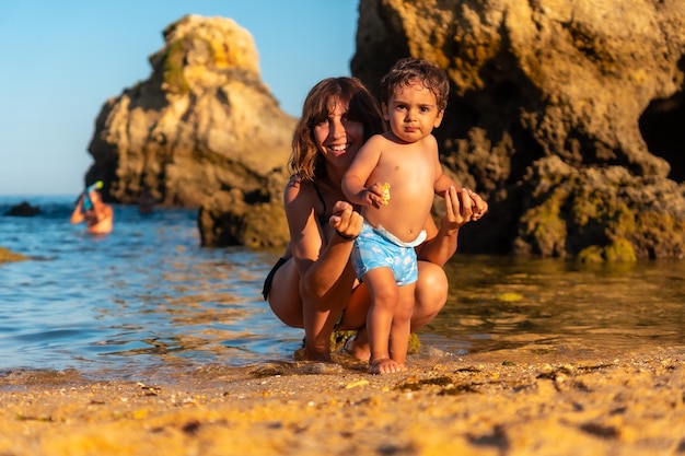 Uma mãe abraçando seu filho na praia na Praia dos Arrifes Algarve beach Albufeira Portugal