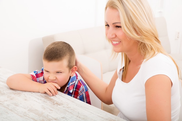 Uma mãe com seus filhos usando um tablet PC em casa.