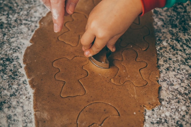 uma mãe e seu filho empenhados na deliciosa tarefa de preparar pão de gengibre de Natal