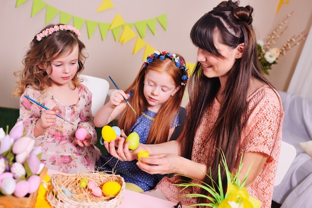 Uma mãe e sua filha estão pintando ovos.