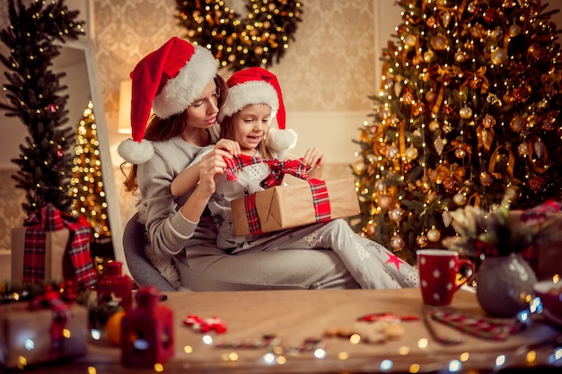 Uma mãe e uma família felizes embalam presentes de Natal