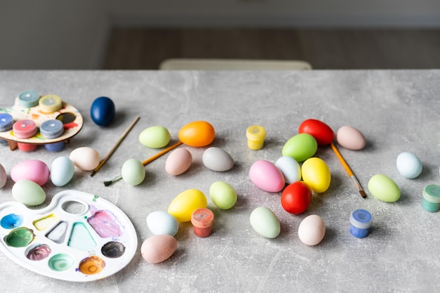 Uma mãe, pai e seus filhos pintando ovos. família feliz se preparando para a páscoa.