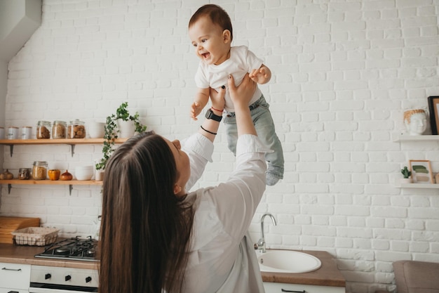 Uma mãe passa o tempo com seu lindo filho segurando-o nos braços e abraçando-o com ternura Conceito de maternidade e infância feliz