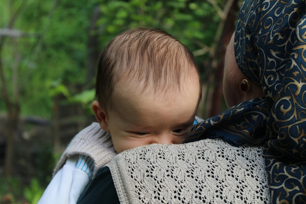 Uma mãe segura seu bebê em uma floresta verde bebê recém-nascido do dia das mães