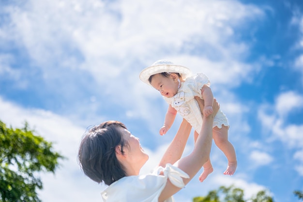 Uma mãe segura seu bebê no ar.