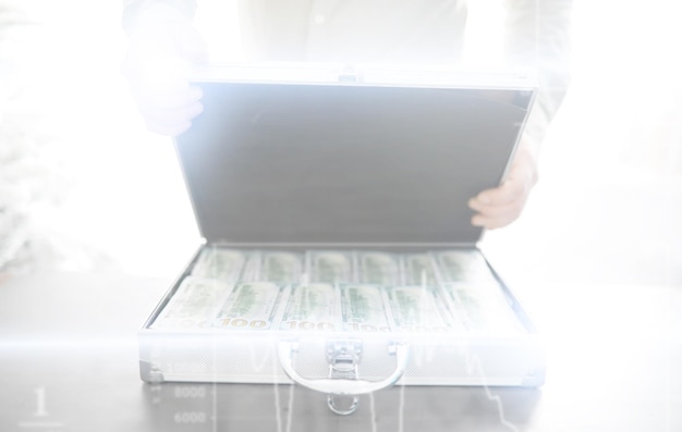 Uma mala de metal cheia de notas americanas de 100 dólares Exposição dupla Conceito de corrupção de suborno de investimento