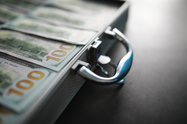 Uma mala de metal cheia de notas de 100 dólares americanos Dupla exposição Conceito de corrupção de suborno de investimento xA