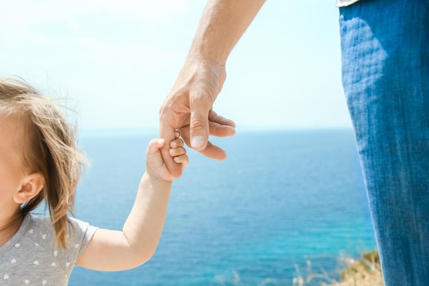 Foto uma mão de pais e filhos felizes no mar em fundo de viagem na grécia