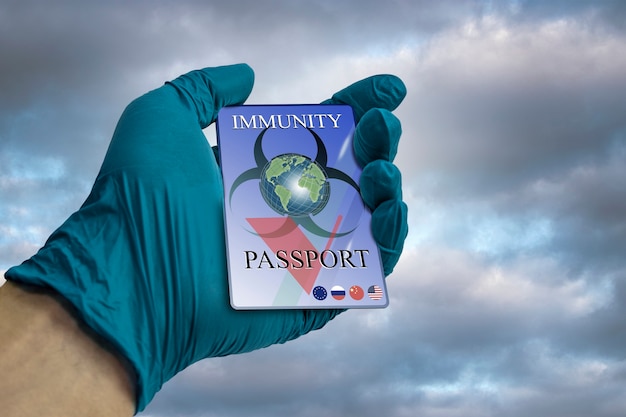 Uma mão em uma luva médica segura um passaporte de imunidade. Passaporte confirmando imunidade ao coronavírus. Documento que confirma a falta de 19. Coronavírus e conceito de segurança. Possibilidade de viajar.
