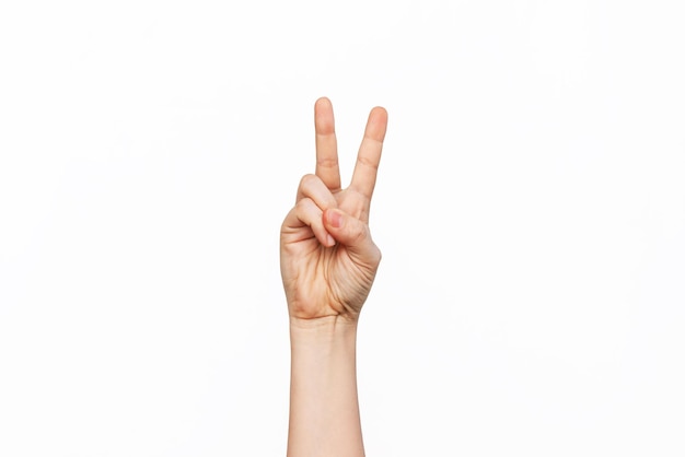 Foto uma mão feminina mostrando um gesto de paz isolado em um fundo branco sinal de mão de vitória