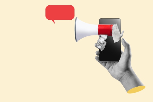 Uma mão humana segurando o megafone através de uma tela de telefone móvel com uma bolha de fala vazia