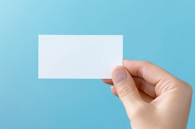Uma mão segurando um cartão de visita em branco contra uma imagem de IA generativa de fundo azul