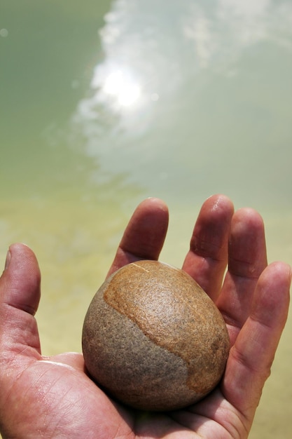 Uma mão segurando uma pedra Homem e natureza