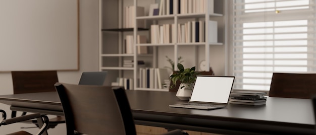 Uma maquete de laptop em uma mesa de reunião na moderna sala de reuniões mínima