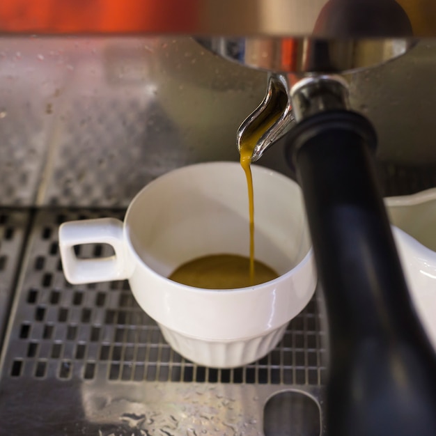 Uma máquina de café prepara dois expresso em dois copos de vidro em um café