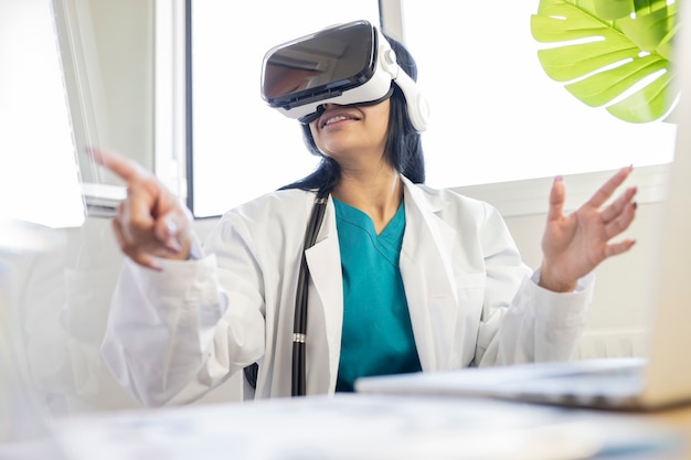 Uma médica bonita em seu consultório com óculos de realidade virtual fazendo gestos