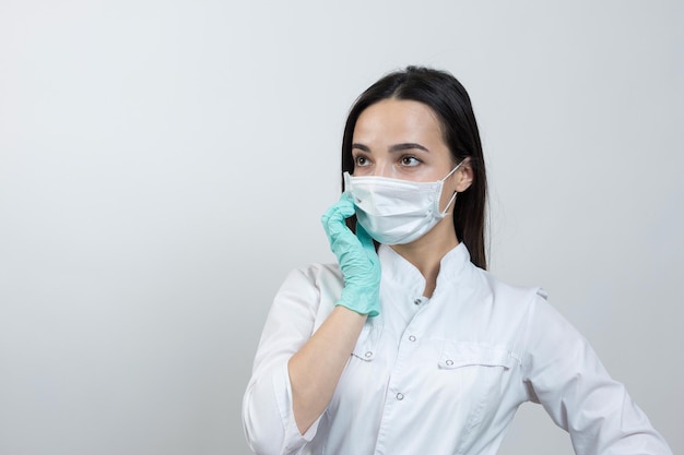 Uma médica com luvas de látex e um jaleco branco se prepara para os procedimentos.