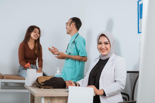 Uma médica de jaleco sentada em sua mesa