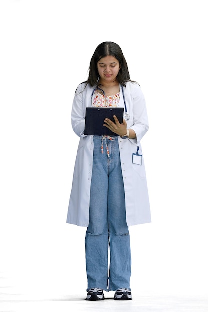 Uma médica em um fundo branco em toda a altura escreve