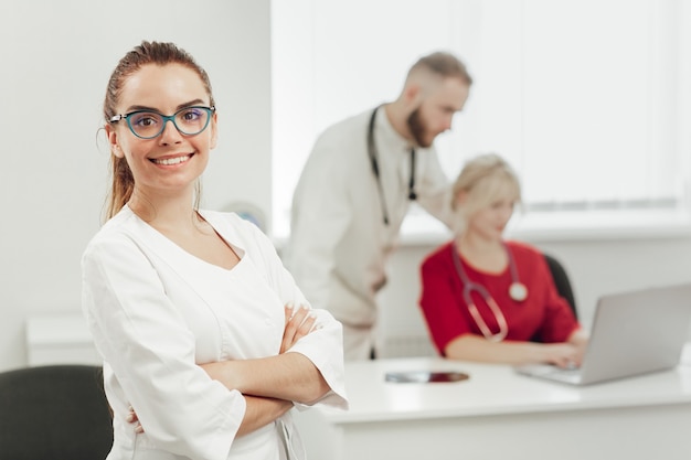 Uma médica morena de uniforme sorrindo