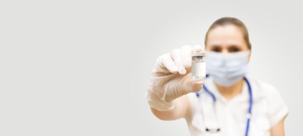 Foto uma médica segura uma ampola com remédio ou vacina na mão