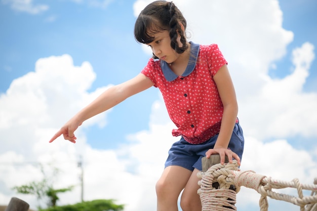 Uma menina a divertir-se num baloiço num dia claro