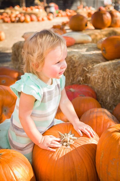 Uma menina adorável a divertir-se num rancho rústico no Pumpkin Patch