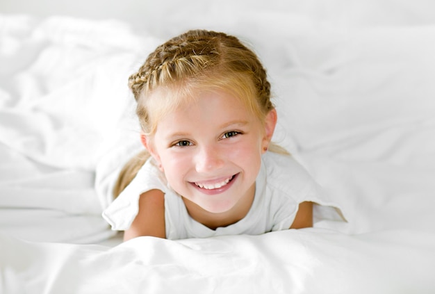 Uma menina adorável acorda na cama.