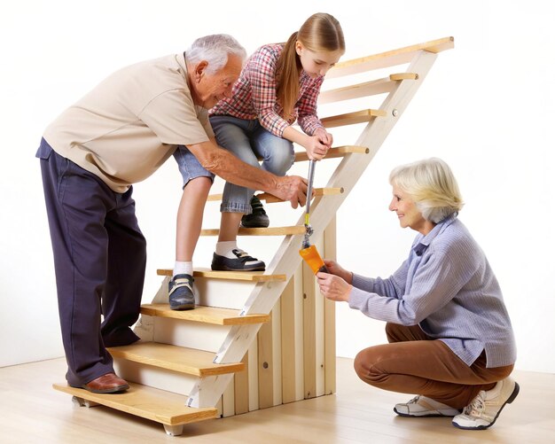Foto uma menina ajudando um casal idoso a reparar uma escada que rangia