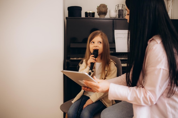 uma menina aprende a cantar numa escola de música