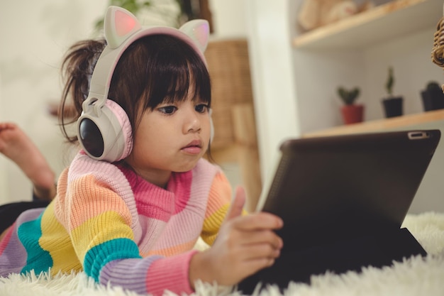 Uma menina asiática feliz ouvindo música na sala de estar