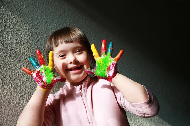 Foto uma menina bonita com as mãos pintadas.