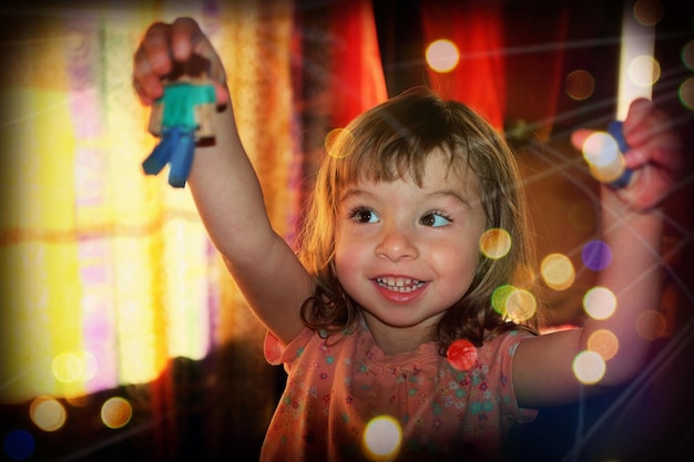 Foto uma menina bonita e sorridente a brincar com brinquedos em casa.