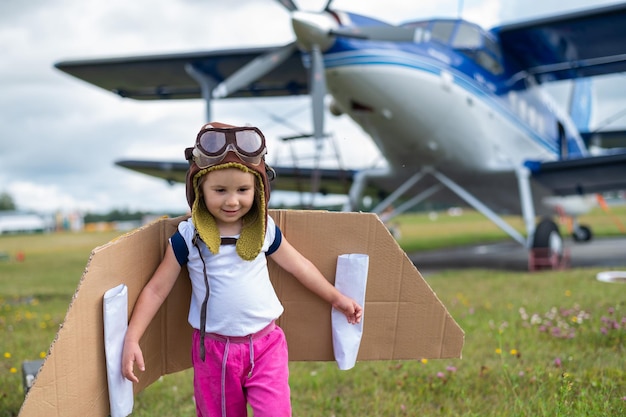 Foto uma menina bonita vestida com um boné e óculos de um piloto no fundo de um avião o