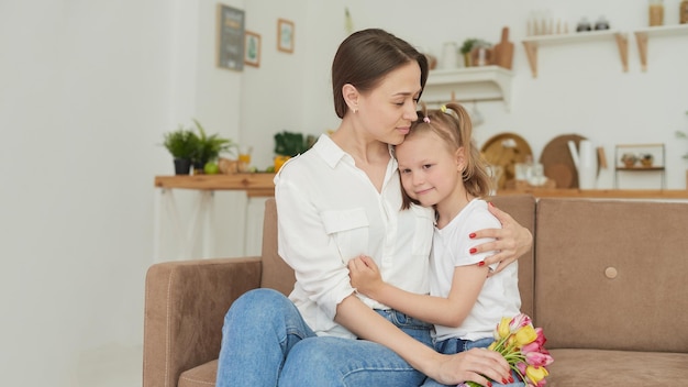 Uma menina bonitinha dá flores e parabeniza sua mãe feliz dia das mães ou 8 de março Webbanner