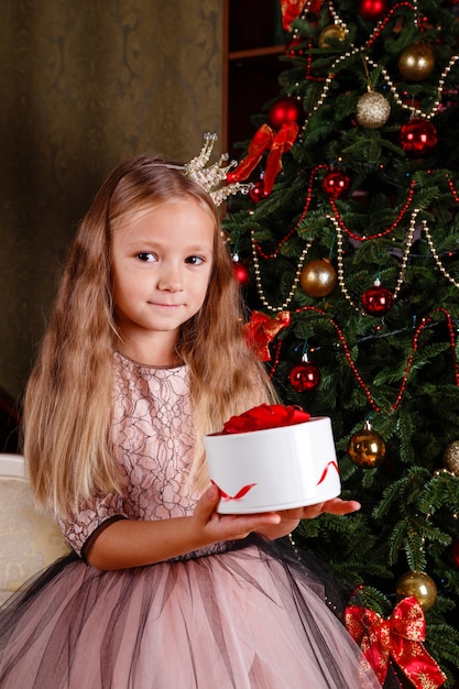 Uma menina bonitinha em um vestido se preparando para o ano novo. na expectativa da festa,