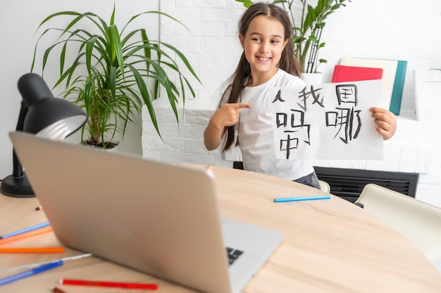 Uma menina branca na lição de caligrafia chinesa. menina aprendendo chinês