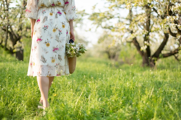 Uma menina caminha por um parque verde, apreciando a natureza florescendo