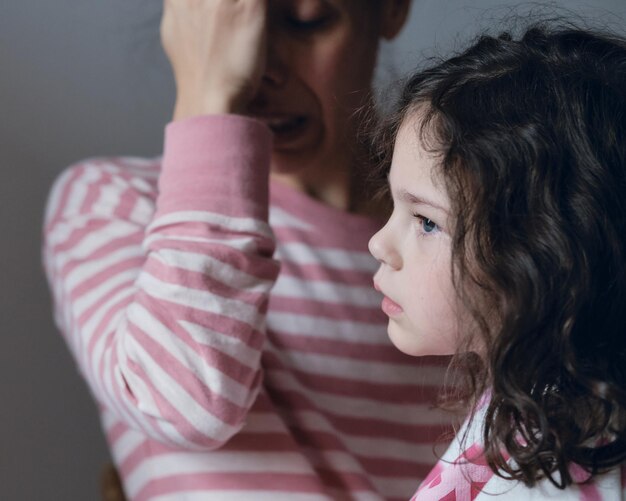 Foto uma menina chateada a ser consolada pela mãe.