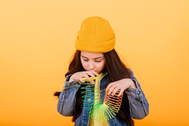 Uma menina com uma camisa multicolorida segura um brinquedo colante multicolor nas mãos