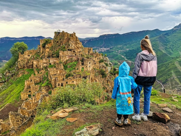 Uma menina com uma criança no fundo da aldeia de Gamsutl nas montanhas do Cáucaso Daguestão Rússia Junho de 2021